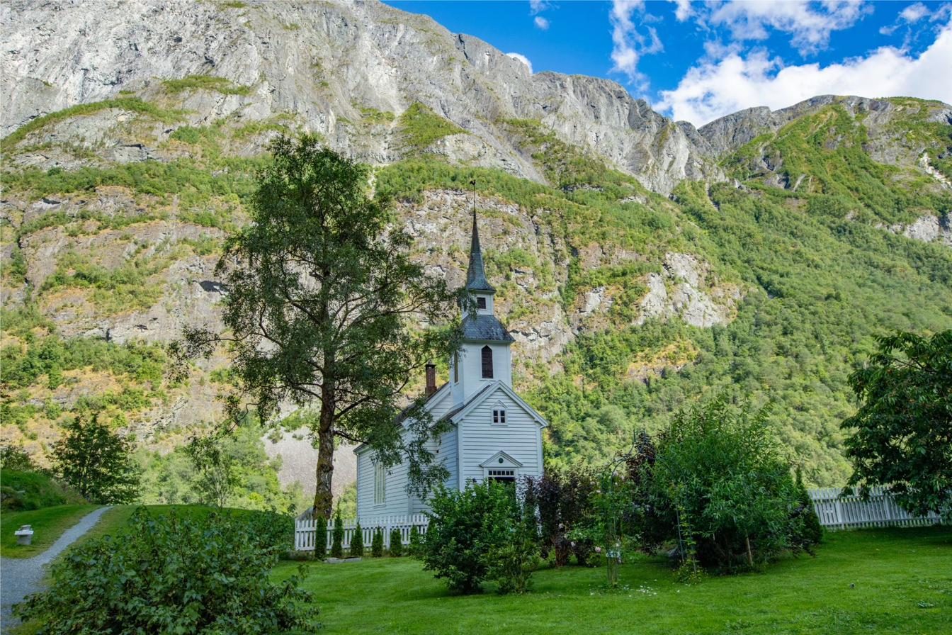 The white wooden church of Bakka from 1859 beneath the mountainside