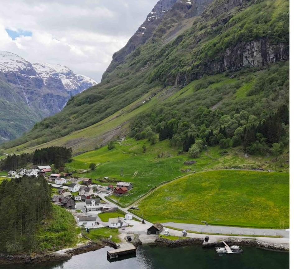 The village of Bakka from above: farms, green fields and the fjord quay