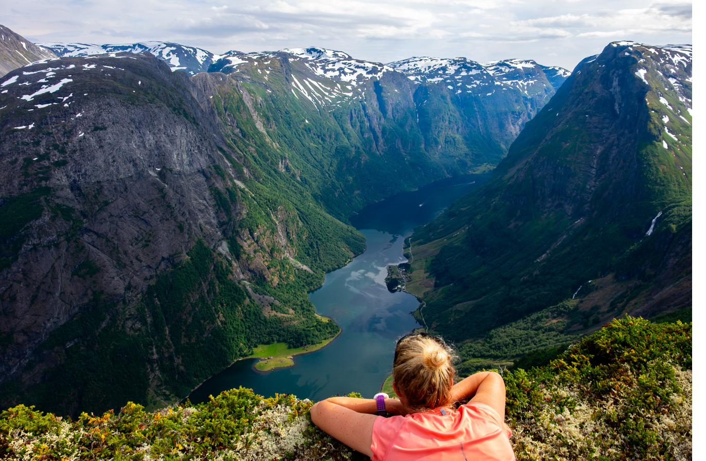 Hiker at Breiskrednosi looking down on the bend of the Nærøyfjord