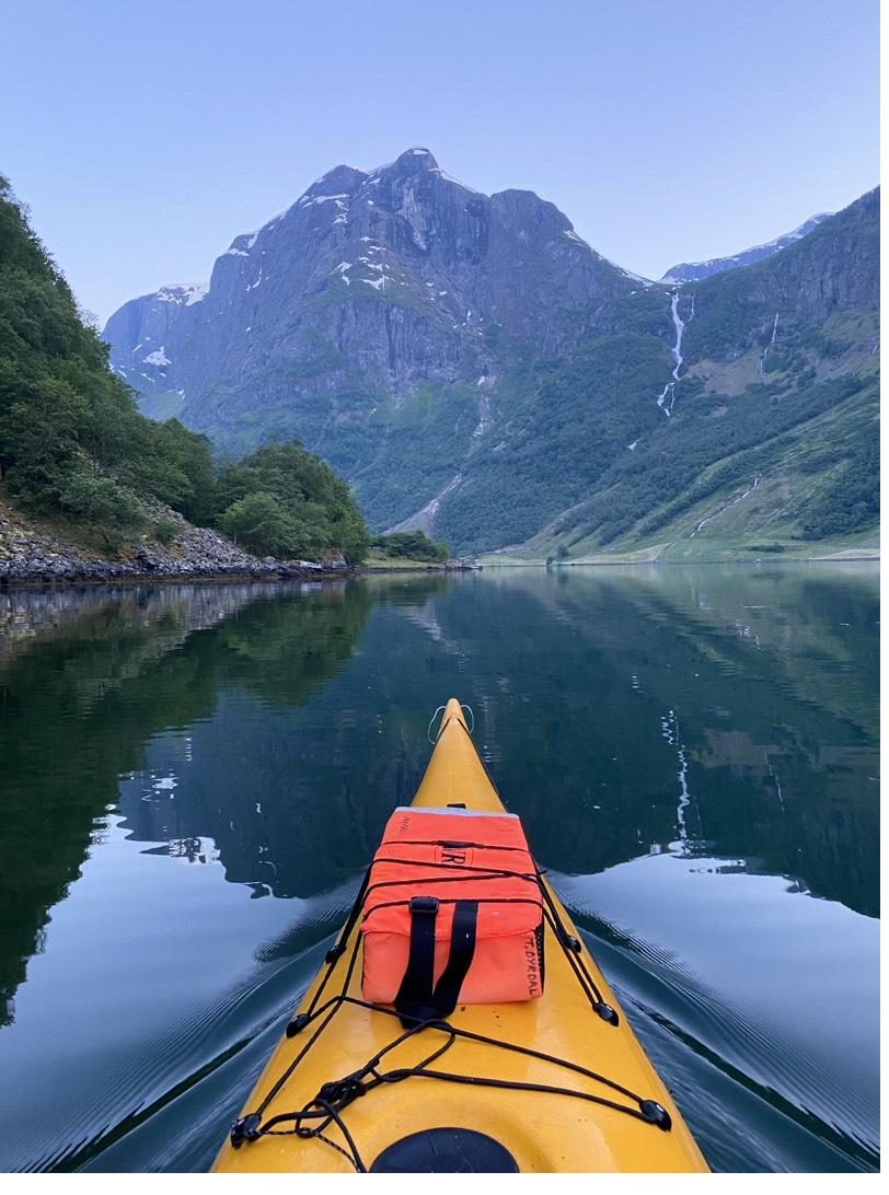 The family kayak on a still morning fjord, a life vest marked Dyrdal on the deck