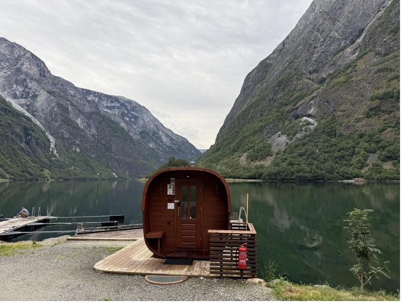 Wooden barrel sauna on the pier with the Nærøyfjord behind it